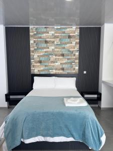 a bedroom with a large bed with a brick wall at Sky Suite in Sogamoso