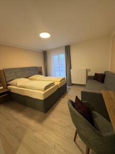 a bedroom with a bed and a couch at Zur Post Wellness und Sporthotel in Tännesberg +16 photos