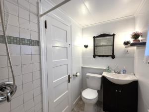 a white bathroom with a toilet and a sink at Cottage 5-6 - 2 Bedroom / 1 Bath End Unit in Wolfeboro +26 photos