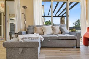 a living room with a gray couch and a chair at Seaview Villa in Peyia with Private pool by VICHY Holidays in Paphos