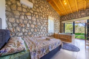 a bedroom with a bed and a stone wall at VillaVista07 in Kaş