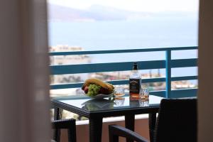 a table with a bottle of beer and a bowl of fruit at Parid Apartment in Polisi i Vogël