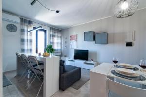 Una cocina y una sala de estar con mesa y sillas. en Bramieri Home - Lecce Selection, en Lecce