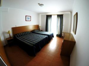 Ένα ή περισσότερα κρεβάτια σε δωμάτιο στο Apartamentos Turísticos Vila Praia
