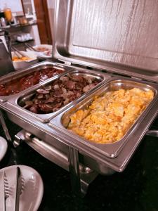two trays of food in a buffet at Alkimia Hotel in Campo Grande
