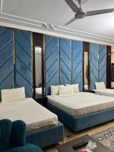 two beds in a room with blue walls at Arizona Lodge Guesthouse in Islamabad