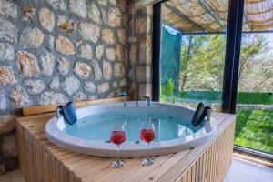 two wine glasses in a jacuzzi tub with windows at VillaVista07 in Kaş +16 photos