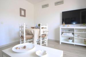 een woonkamer met een tafel en een tv bij Casa Sol in Son Parc +5 foto's