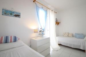 een witte slaapkamer met een bed en een raam bij Casa Sol in Son Parc