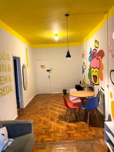 d'un salon avec une table et des chaises et un plafond jaune. dans l'établissement Apê Marie I Maletta, Mercado Central e Minascentro, à Belo Horizonte