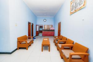 a waiting room with orange chairs and a table at Guesthouse Andalusia Gontor 1 Ponorogo in Ponorogo