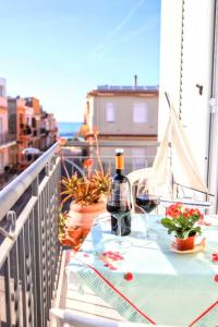 une table avec deux verres de vin sur un balcon dans l'établissement Appartamento L'airone Balestrate, à Balestrate 20 autres photos