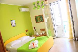 um quarto com uma cama com paredes verdes e uma janela em Appartamento Il Gabbiano Balestrate em Balestrate