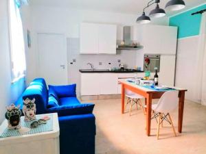 uma sala de estar com um sofá azul e uma mesa em Appartamento Il Gabbiano Balestrate em Balestrate