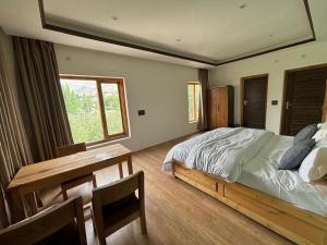 a bedroom with a bed and a table and a window at Skyline Homestay in Leh