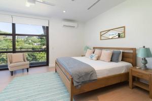 a bedroom with a bed and a large window at La Perla 161-Oceanview,Penthouse,Walking Distance in Tamarindo +23 photos