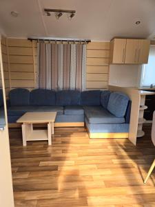 a living room with a blue couch and a table at camping Pradon in Arnuero