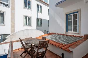 Un balcón con una mesa y sillas en un edificio. en Central Ericeira Beach!, en Ericeira