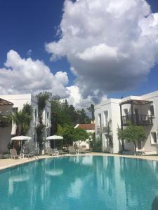 a large blue swimming pool in front of two buildings at Meis Hotel in Bitez