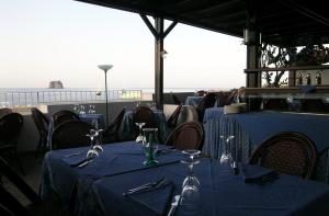 a restaurant with blue tables and chairs with a view of the ocean at La Sirenetta Park Hotel in Stromboli