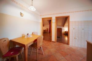a kitchen and dining room with a wooden table and chairs at Green Escape garni hotel in Postojna