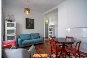 Una sala de estar con una mesa y un sofá azul. en Central Ericeira Beach!, en Ericeira 31 fotos más