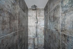y baño con ducha y pared de piedra. en Central Ericeira Beach!, en Ericeira