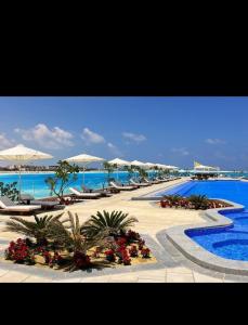 阿莱曼Marassi beachfront escape, Address beach resort的一个带遮阳伞和海滩的度假村