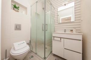 a bathroom with a toilet and a glass shower at Alegria's House in Odiáxere +38 photos