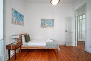 Un dormitorio con una cama y una mesa con una lámpara. en Central Ericeira Beach!, en Ericeira