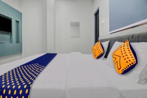 a bedroom with a bed with orange and blue pillows at Hotel O The VNP Inn in Sakardarā +20 photos