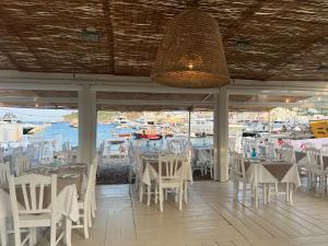 a restaurant with white tables and chairs and a chandelier at Pensione Silvia Santa Marì in Ponza +44 photos