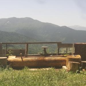 a wooden bench in a field with mountains in the background at Bed and water in Plav