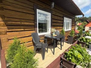 a wooden deck with a table and chairs on it at Chatka na Bečvách in Prostřední Bečva