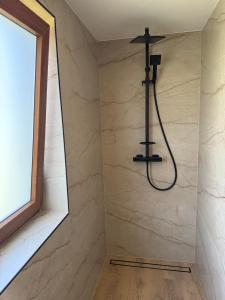 a shower in a bathroom with a window at Chatka na Bečvách in Prostřední Bečva +17 photos