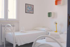 a white room with two beds and a tv at AP Apartment - Baia Verde in Baia Verde +4 photos