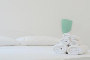 a pile of towels sitting on a counter in front of a mirror at AP Apartment - Baia Verde in Baia Verde