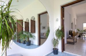 a hallway with potted plants and a mirror at Coral Bay Avenue Villa by Vichy Holidays in Paphos
