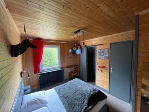 a bedroom with a bed in a wooden room at Le CHALET in Gérardmer