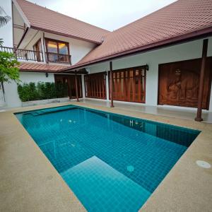 une piscine devant une maison dans l'établissement Baan thai pool villa pattaya, à Jomtien Beach 5 autres photos