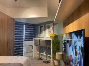 a bedroom with a bed and a desk with two chairs at KRYSTL KRIB Azure North in San Fernando