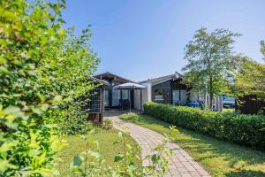 una casa con un passaggio pedonale in mattoni nel cortile di Ferienwohnpark Immenstaad am Bodensee Satteldachhaus Typ 9 SD 19 a Immenstaad am Bodensee