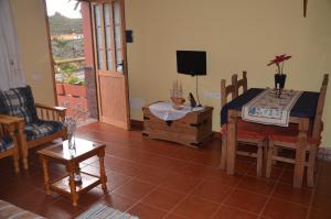a living room with a table and chairs and a television at Rural Gomera in Arure