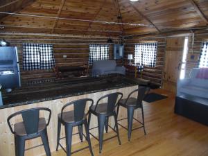 a bar in a cabin with chairs and a couch at New! The Hideout - Cute And Quiet Rustic Cabin! in Oscoda
