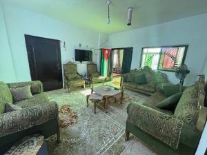 a large living room with couches and a tv at Leith Holiday Home in ‘Ayn Jannā
