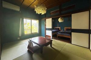 una habitación con una mesa y una cama y un espejo en Lotus House Kamakura, en Kamakura
