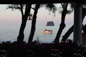 a sail boat in the water with a rock in the ocean at La Sirenetta Park Hotel in Stromboli