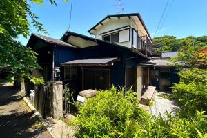 una casa azul con un banco delante en Lotus House Kamakura, en Kamakura