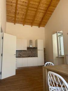 a kitchen with white cabinets and a wooden floor at Peacock apartments Latina in Latina +8 photos