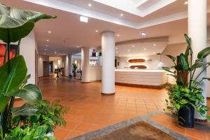 a lobby with plants and a kitchen in the background at Pestana Ocean Bay Resort in Funchal +33 photos
